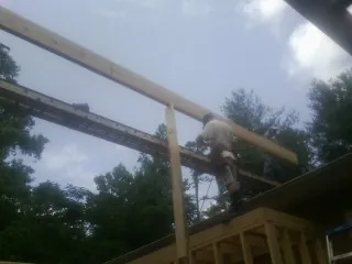 Carpenter setting a ridge beam over a new addition frame — Ice Dam Removal by Roofing Brothers in Phoenixville