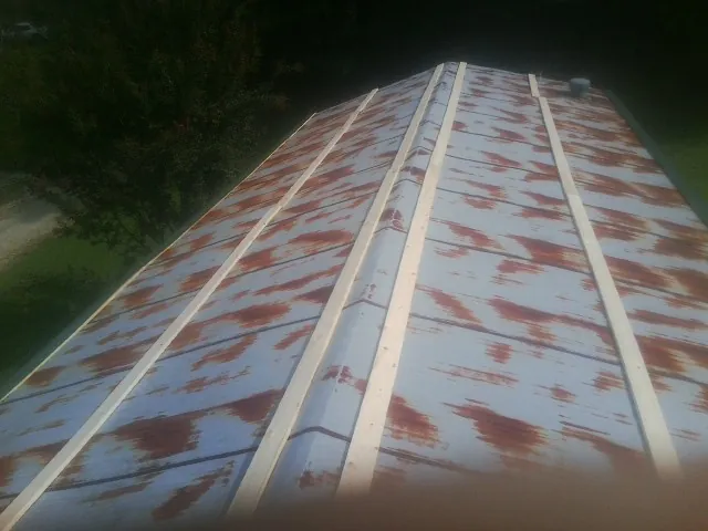 Rusted metal roof panels with new wood purlins before replacement — Storm Damage Roof Repair in Phoenixville by Roofing Brothers