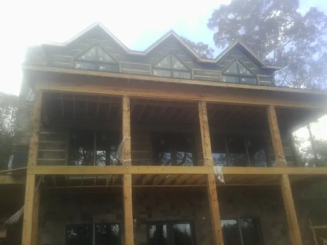Dormers and porch framing on a large log home under construction — Roof Coating work by our crew in Phoenixville