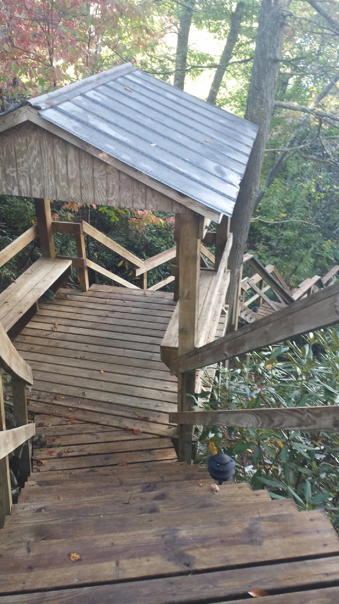 Metal roofed shelter over wooden steps on a wooded walkway — Skylight Repair & Installation work by our crew in Phoenixville